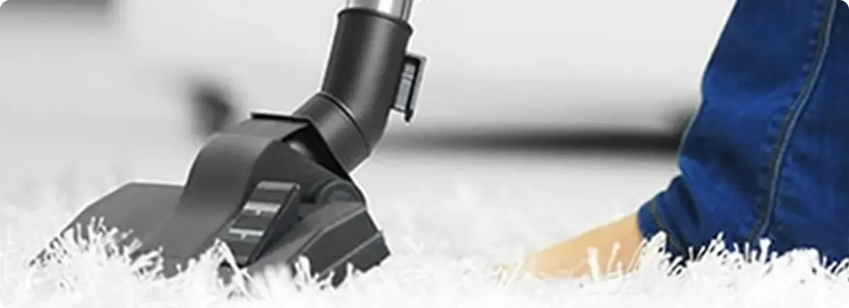 Close-up of a professional vacuuming a white carpet in Kearny.